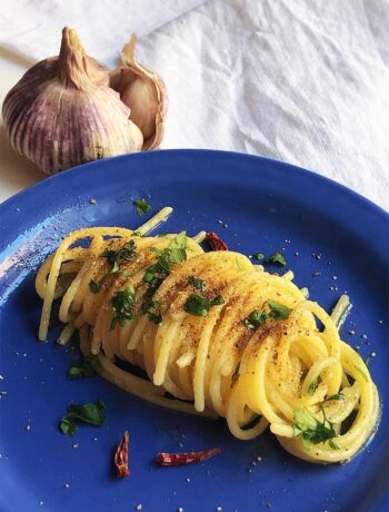 pasta on a blue dish with garlic on the background italian cooking tips