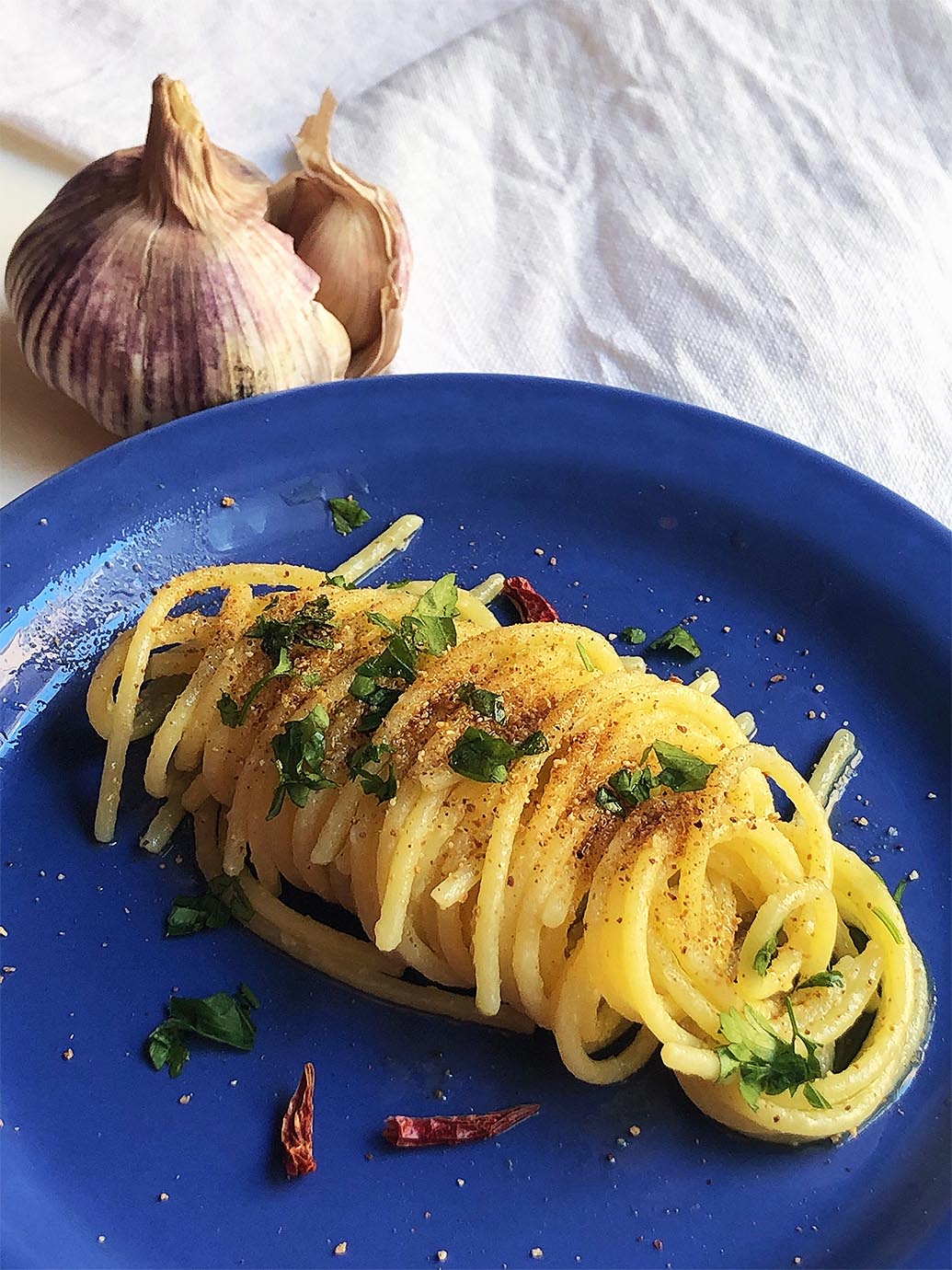 pasta on a blue dish with garlic on the background italian cooking tips