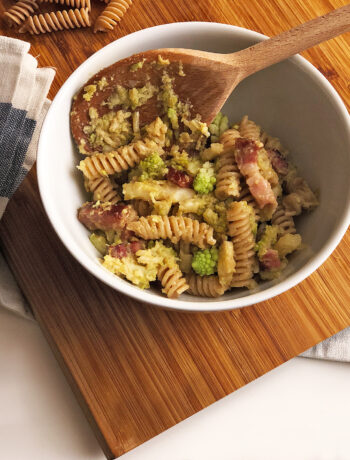 pasta with broccoli into a pan on a chop board