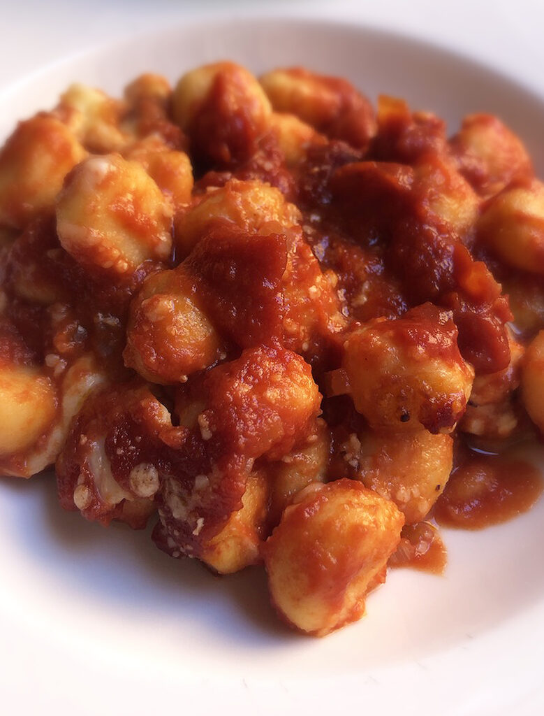 close up of gnocchi alla sorrentina served on a white dish