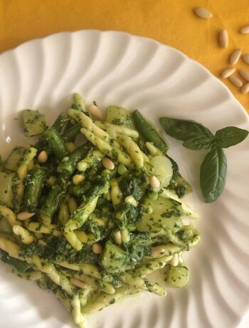 pasta with pesto sauce in a white dish