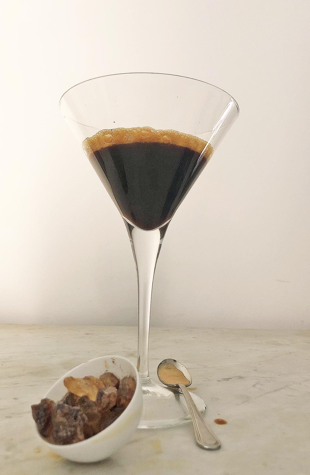 shaken coffee in a cocktail glass with raw sugar crystals