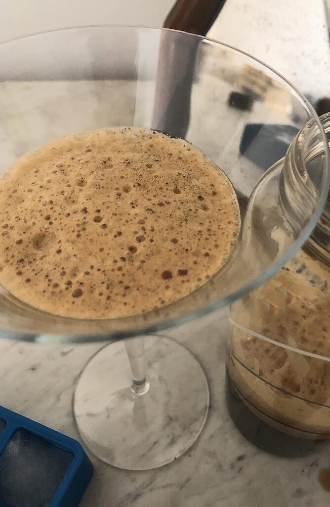 shaken coffee in a cocktail glass topped with its lovely amber foam