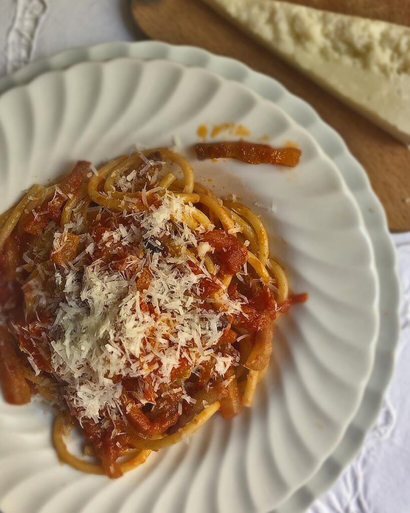 close up of Bucatini alla amatriciana served in a white plate