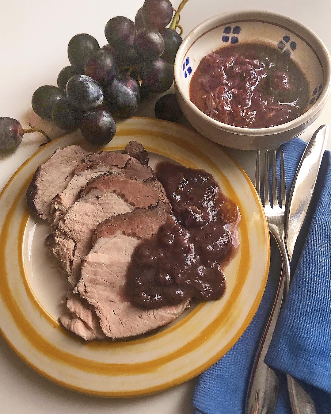 grape roasted pork on a dish with it's lovely grape sauce