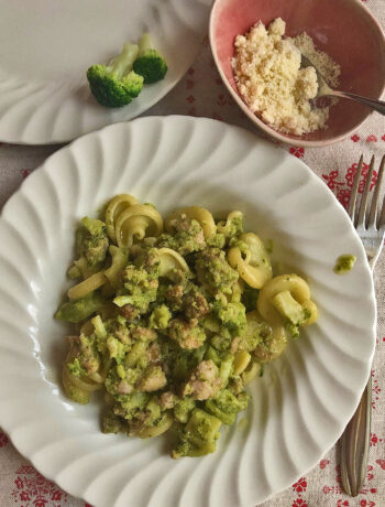 pasta with broccoli and sausage served on a white dish