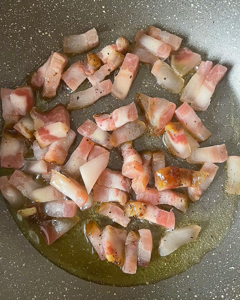 Pork cubes cooked in a skillet with oil