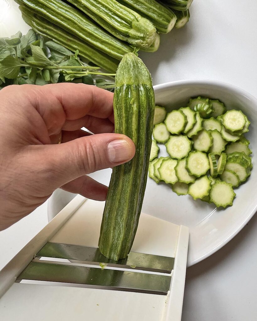 cutting zucchini with a slicer