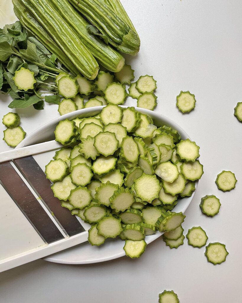 cutting zucchini with a slicer