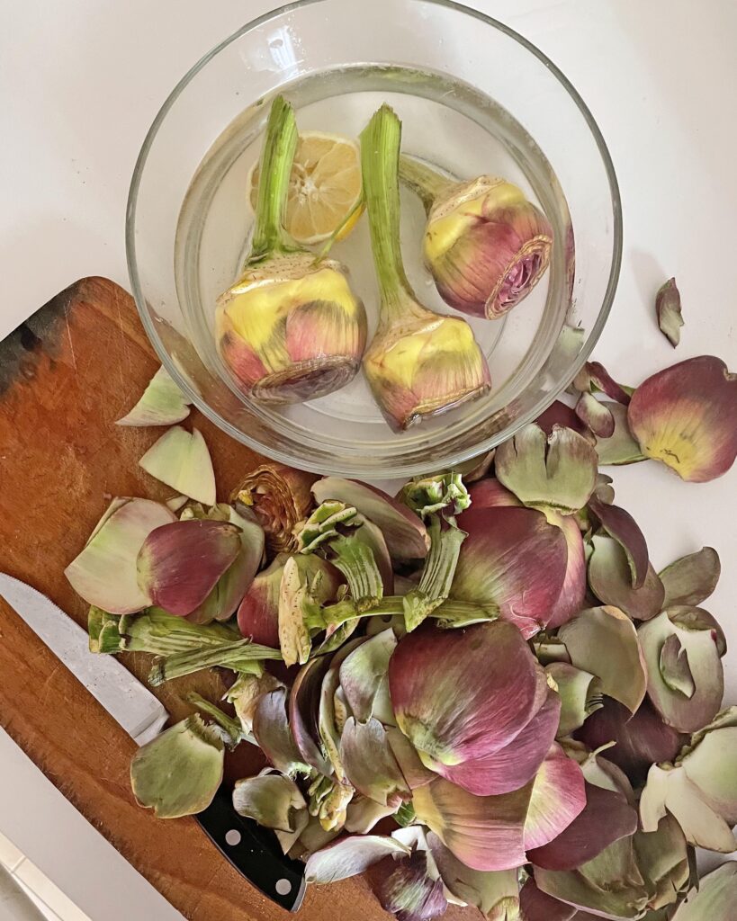 cleaned artichokes rest in water and lemon