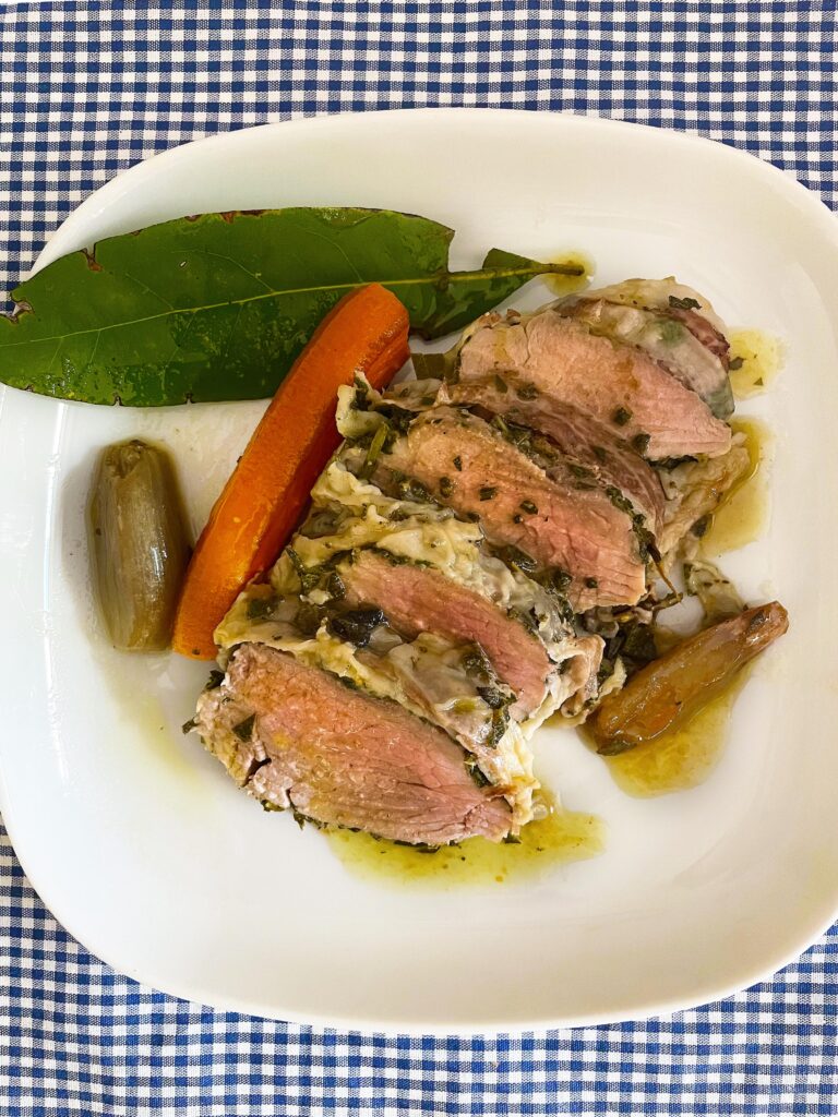 pork fillet with herbs served in a white dish