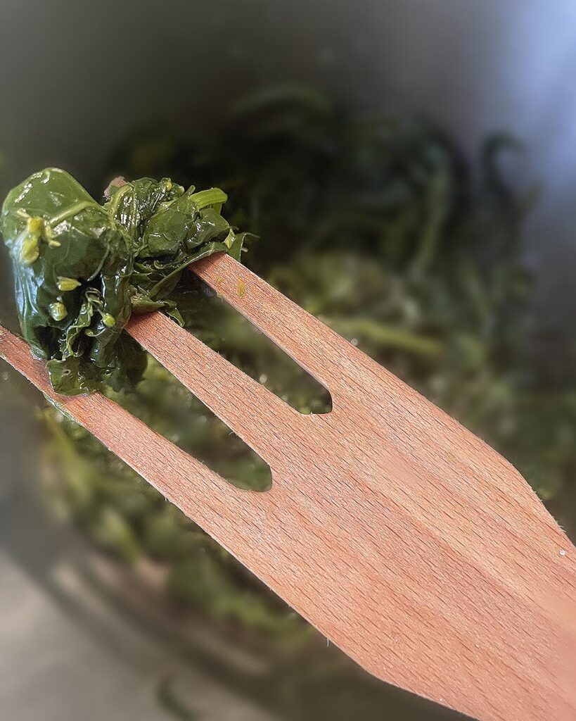 holding turnip green with a wood fork