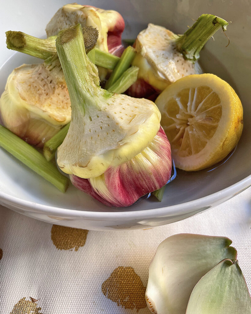 artichokes rest in water and lemon befoer to be cooked