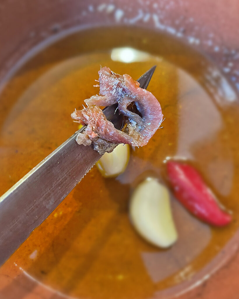 garlic, peperoncino and a fillet of anchovy in oil