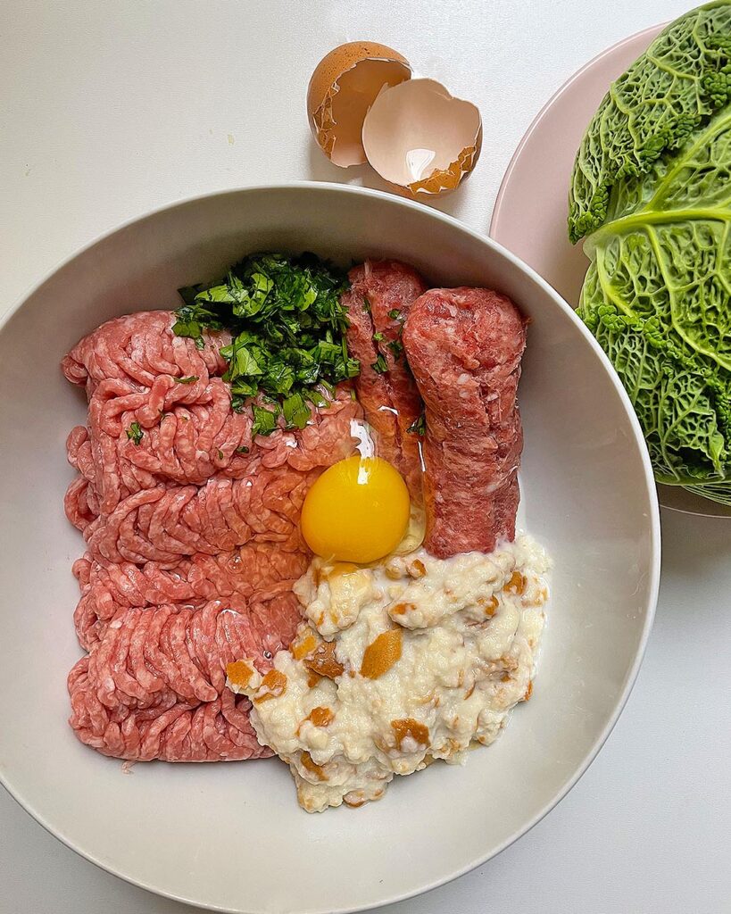 ingredients for cabbage rolls: sausage, chopped meat, eggs, parsley, bread