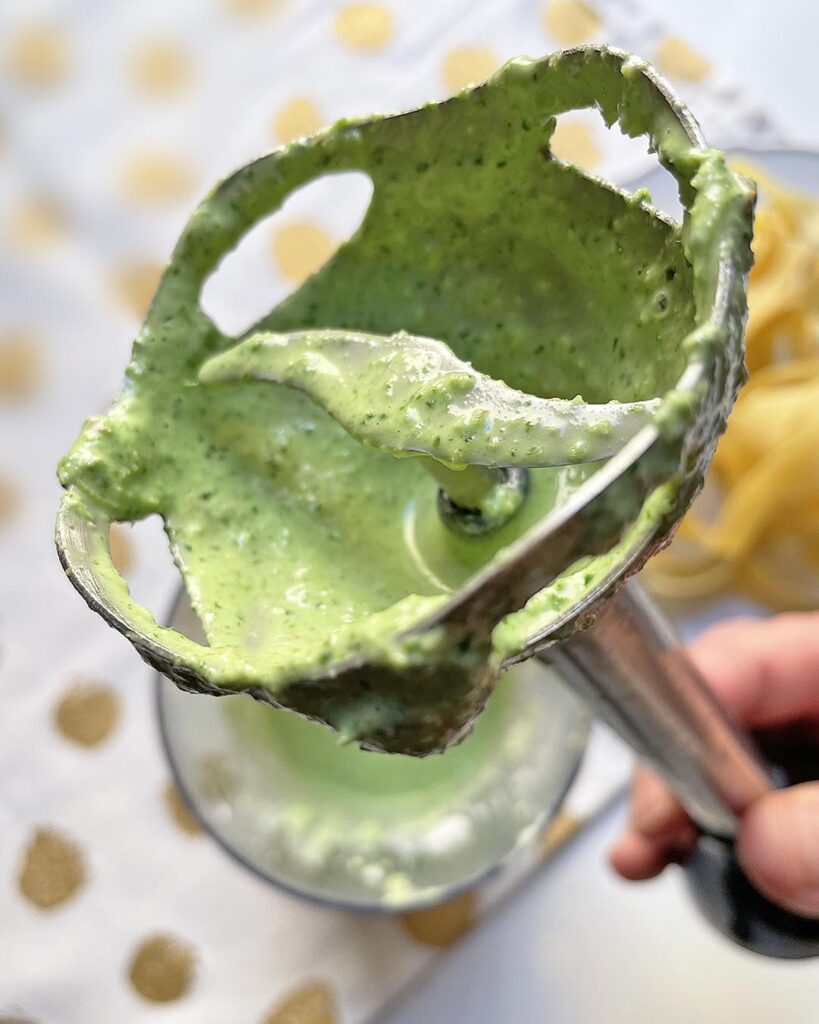 close up of blender blades with pesto