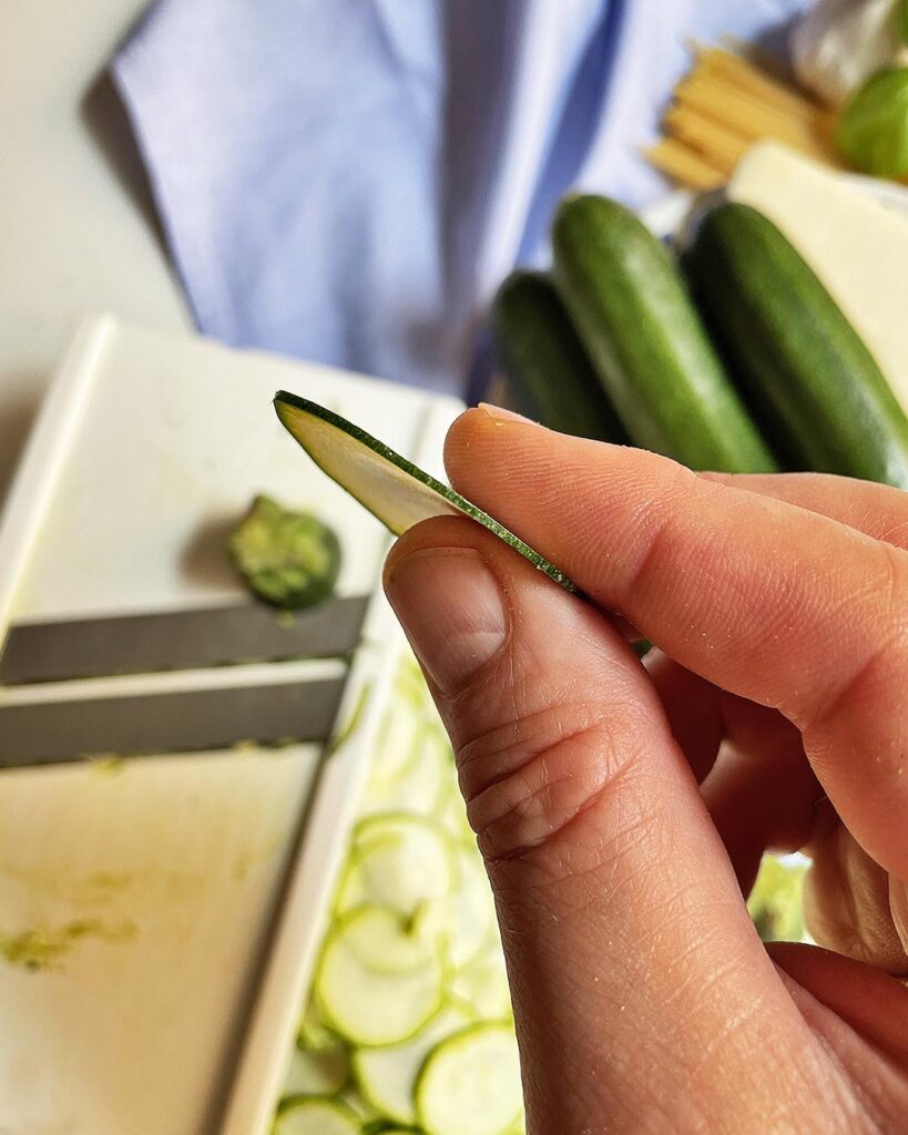 closeup of a thin zucchini slice for for spaghetti alla nerano
