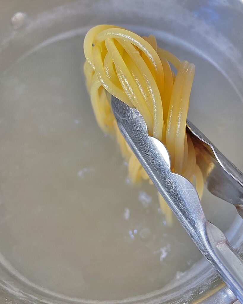 draining cooked spaghetti from water